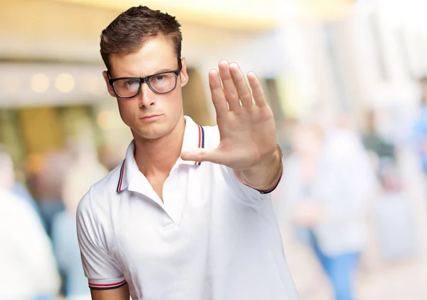 Porträtt av en stilig ung man gör en stop-symbol — Stockfoto