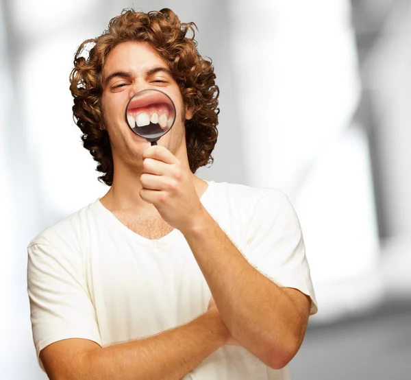 Homem examinando seus dentes com lupa — Fotografia de Stock