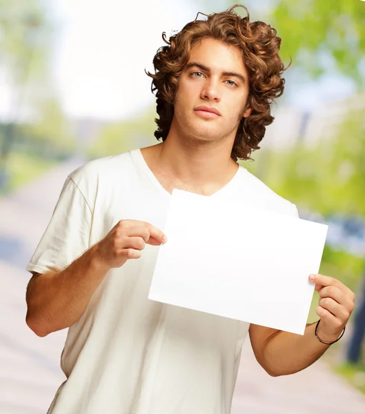 Молодой человек, держащий в руках пустое послание — стоковое фото