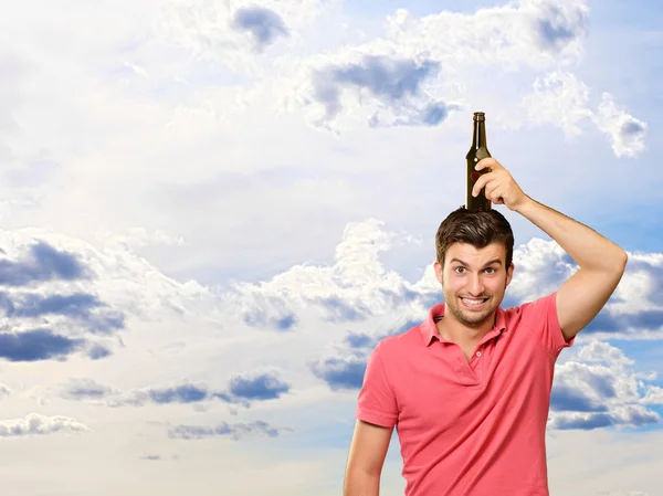 Retrato de un joven sosteniendo una botella en la cabeza —  Fotos de Stock