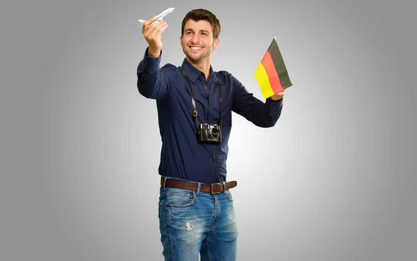 Fotograaf holding Duitse vlag en miniatuur vliegtuig — Stockfoto