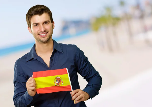 Homem jovem segurando a bandeira da Espanha — Fotografia de Stock