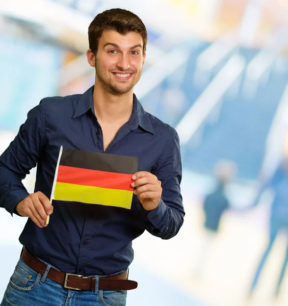 Homem jovem segurando a bandeira da Alemanha — Fotografia de Stock