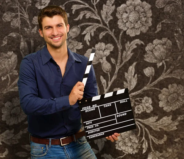 Felice giovane uomo tenendo Clapboard — Foto Stock