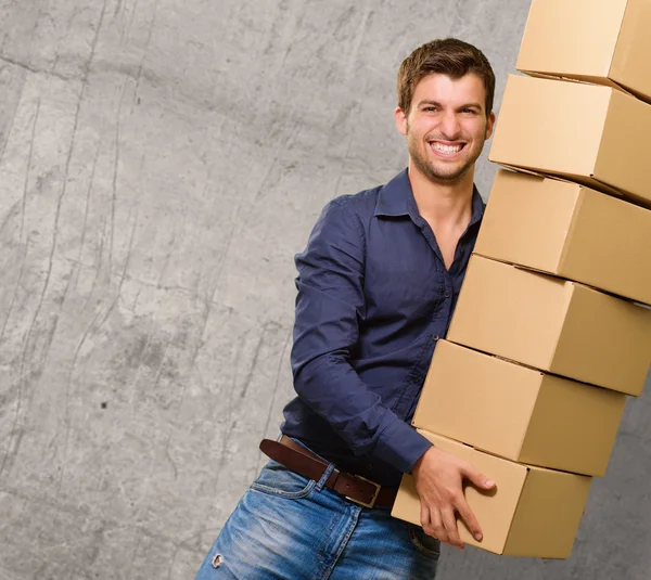 Junger Mann hält Stapel Kartons in der Hand — Stockfoto