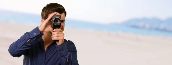 Hombre joven sosteniendo la cámara — Foto de Stock