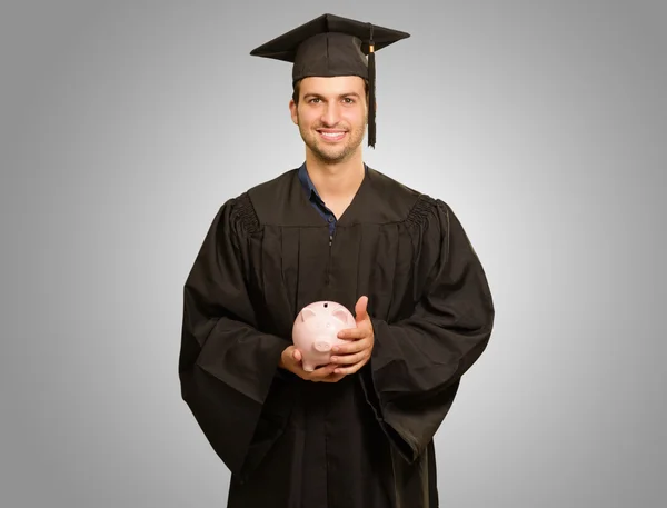 Piggybank hombre graduado holding — Foto de Stock