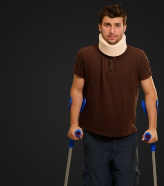 koltuk değneği ile boyun brace yürüyen adam