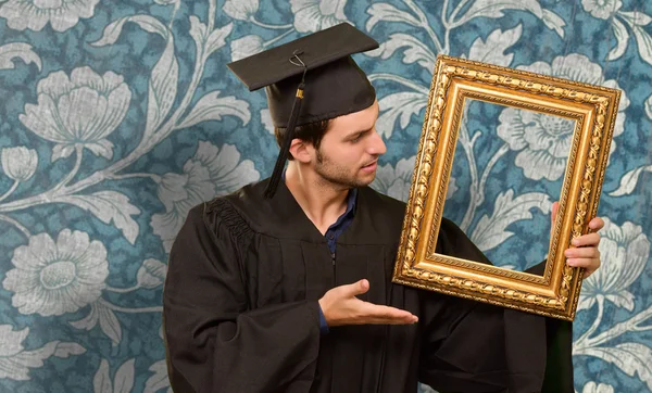Hombre graduado mostrando un marco — Foto de Stock