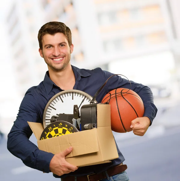 Šťastný mladý muž, který držel cardboxes ukázal — Stock fotografie