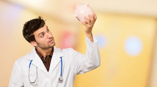 Young Doctor Holding Piggy Bank — Stock Photo, Image