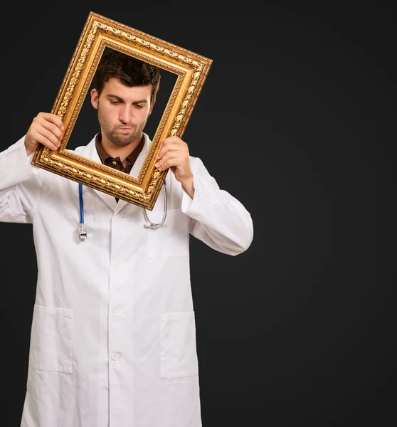 Expressive Young Doctor Holding Frame — Stock Photo, Image