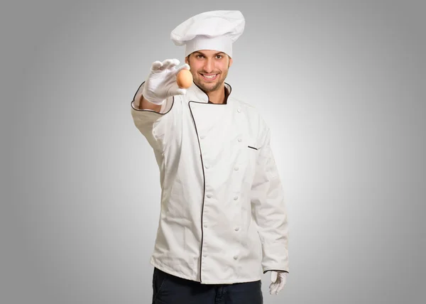 Retrato de un joven chef sosteniendo huevo — Foto de Stock