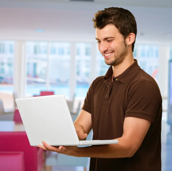 Szczęśliwy młody człowiek pracuje na laptopie — Zdjęcie stockowe