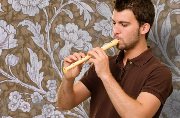 Porträt eines jungen Mannes, der Flöte spielt — Stockfoto