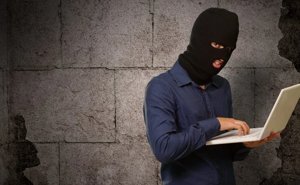 Young male thief holding laptop — Stock Photo, Image