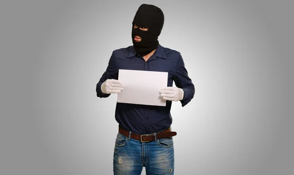 Mann mit Räubermaske zeigt leeres Papier — Stockfoto