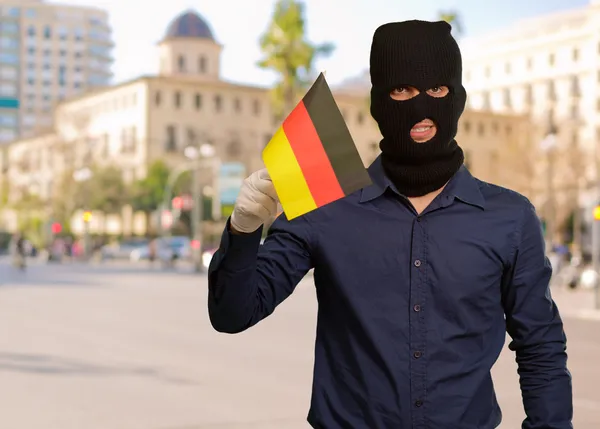 Soyguncu maske takıyor ve bayrak tutan adam — Stok fotoğraf