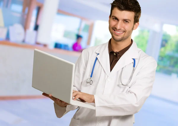 Genç erkek doktor holding laptop Stok Resim