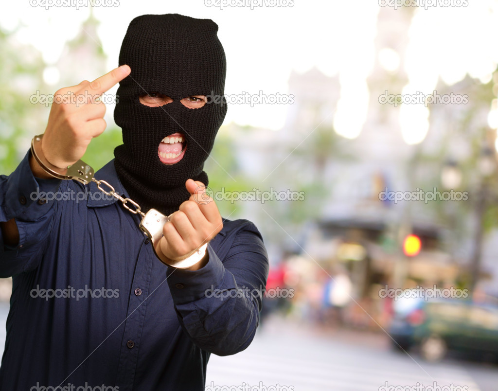 angry criminal man locked in handcuffs