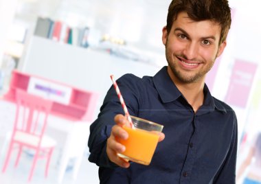 bardak portakal suyu tutan genç adam