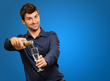 mutlu genç adam şampanya cam içine dökme