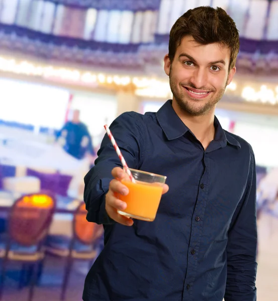 Νέος άνθρωπος που κρατά ποτήρι χυμό πορτοκαλιού — Φωτογραφία Αρχείου