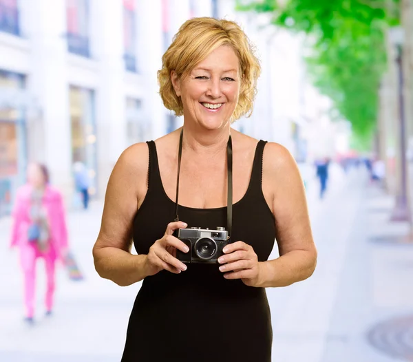 Volwassen vrouw bedrijf camera — Stockfoto