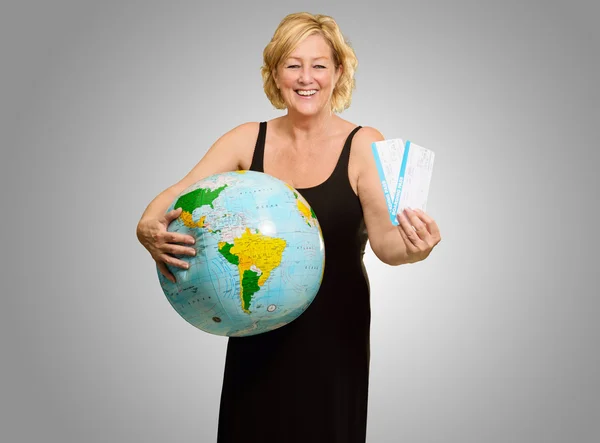 Volwassen vrouw holding globe en boarding pass — Stockfoto