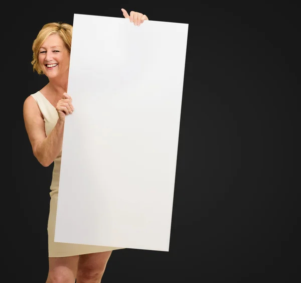 Mujer madura feliz sosteniendo la placa en blanco — Foto de Stock