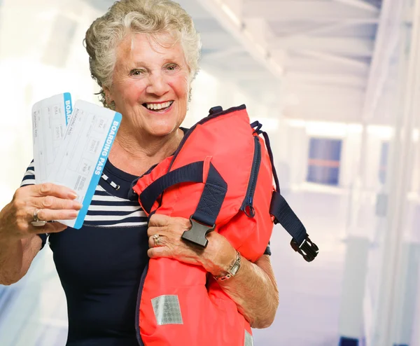 Maturo donna holding imbarco pass e borsa — Foto Stock