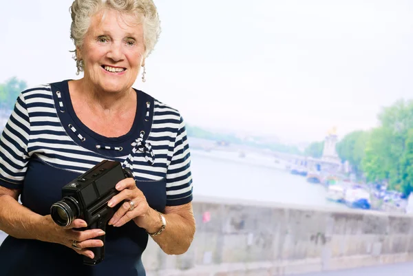 Senior vrouw bedrijf camera — Stockfoto