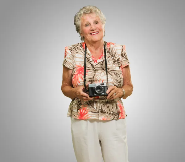 Пожилая женщина держит фотоаппарат — стоковое фото