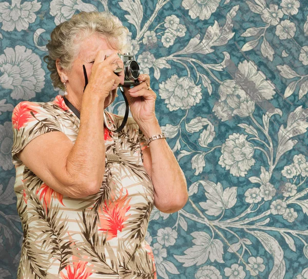 Starší žena zachycení fotografie — Stock fotografie