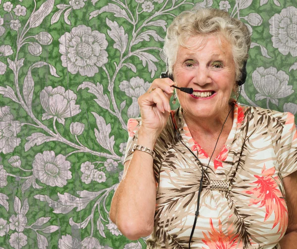 Retrato de mulher sênior alegre com fone de ouvido de telefone — Fotografia de Stock