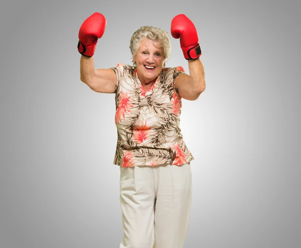 Mujer madura feliz usando guante de boxeo —  Fotos de Stock
