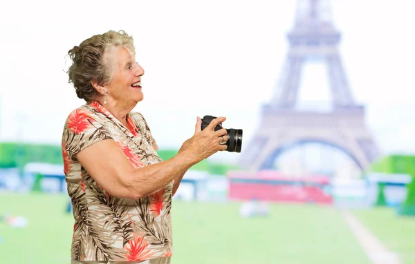 Donna anziana che tiene macchina fotografica — Foto Stock