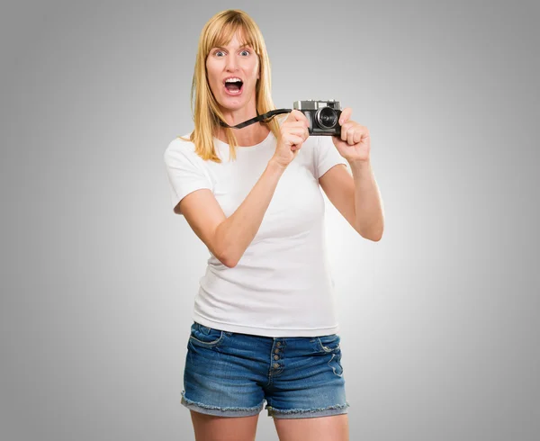 Geschokt vrouw met oude camera — Stockfoto