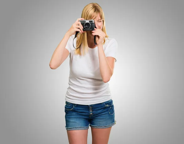 Mulher olhando através da velha câmera — Fotografia de Stock