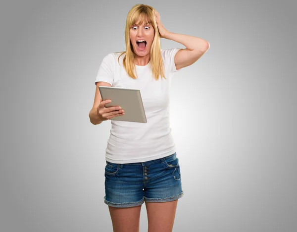 Mujer conmocionada mirando la tableta digital — Foto de Stock