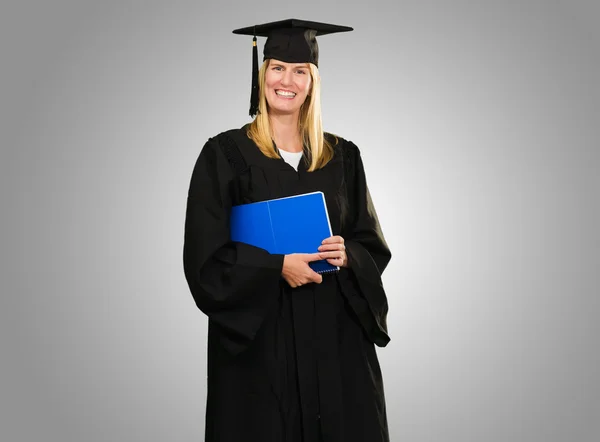 Feliz graduada mujer sosteniendo un cuaderno —  Fotos de Stock