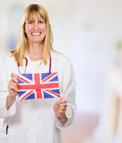 Mutlu doktor holding İngiliz bayrağı — Stok fotoğraf