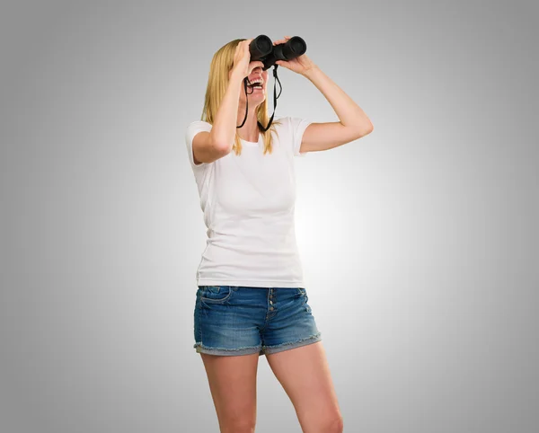 Vrouw die door een verrekijker kijkt — Stockfoto