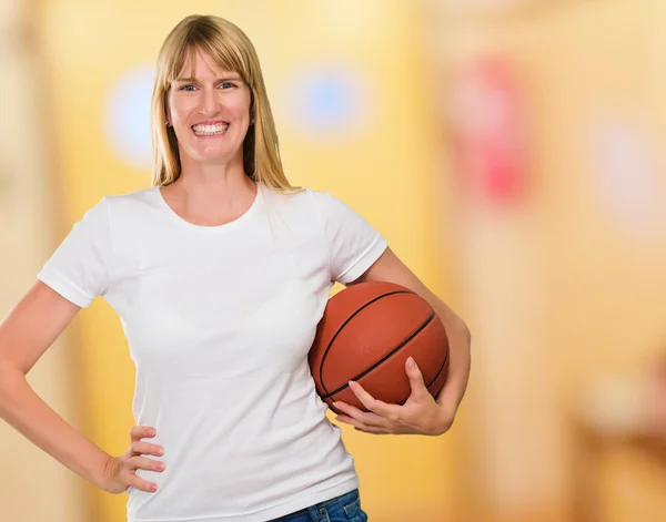 Mulher feliz segurando uma bola cesta — Fotografia de Stock