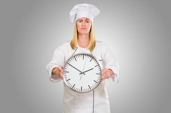 Chef femenino que sostiene el reloj — Foto de Stock
