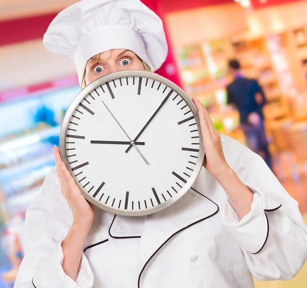 Orolig kock gömmer sig bakom en klocka — Stockfoto