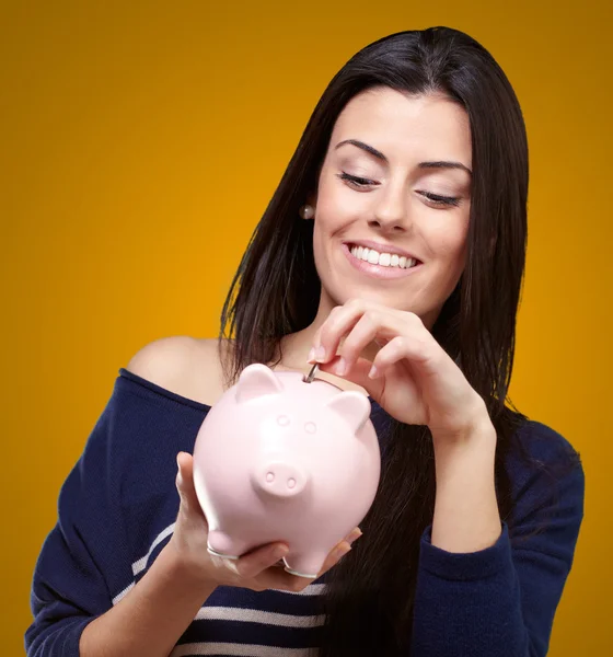 Retrato de uma jovem segurando um banco porquinho — Fotografia de Stock