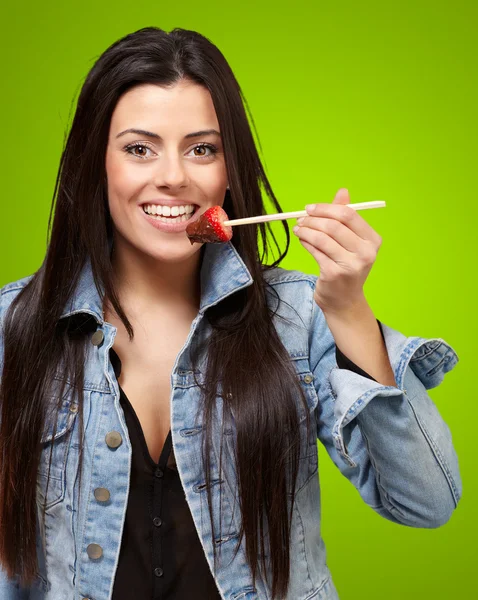 Retrato de uma fêmea comendo morango com molho de chocolate — Fotografia de Stock