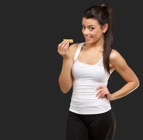 Молодая женщина ест батончик — стоковое фото