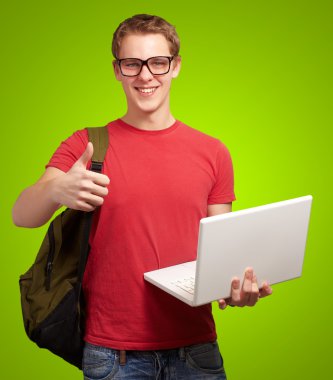 adam tutarak laptop ve sırt çantası